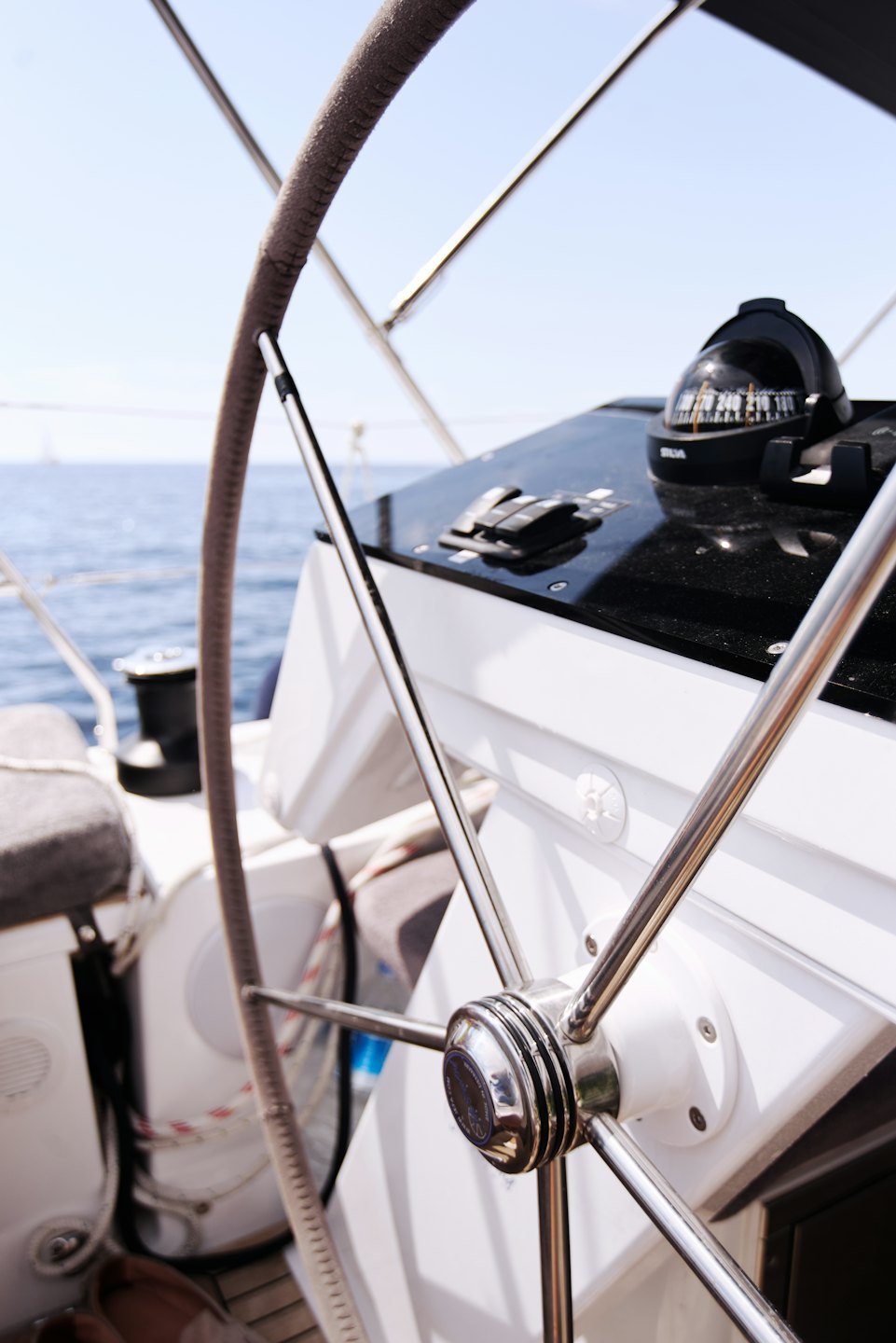 Timone di una barca a vela e bussola marina in una giornata di sole.