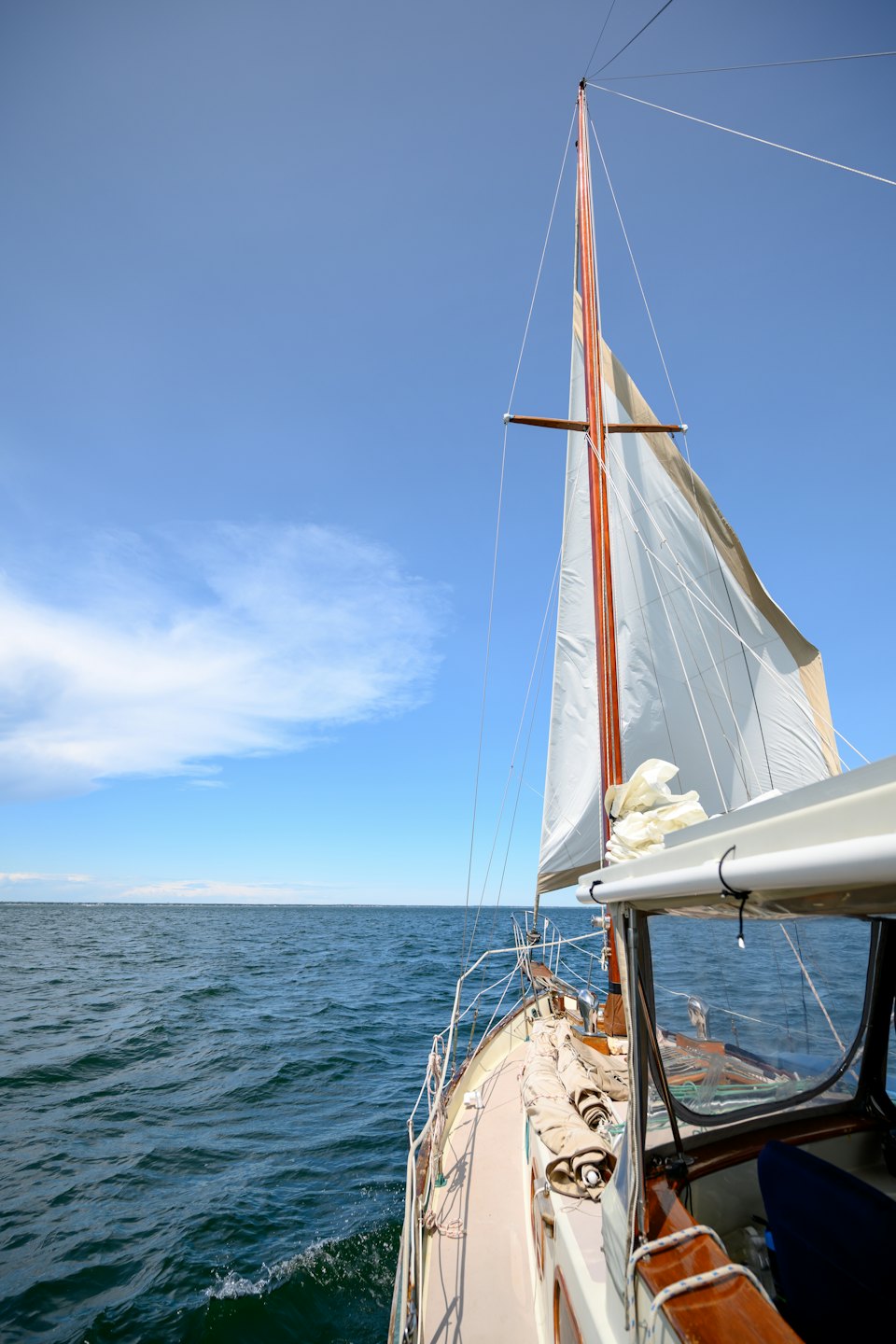 Una barca a vela scivola sul calmo oceano blu.