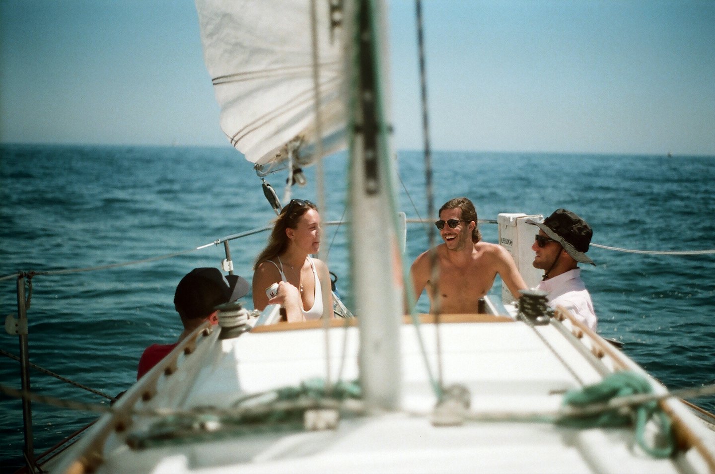 Quattro amici si godono un rilassante pomeriggio in barca a vela sull'oceano.