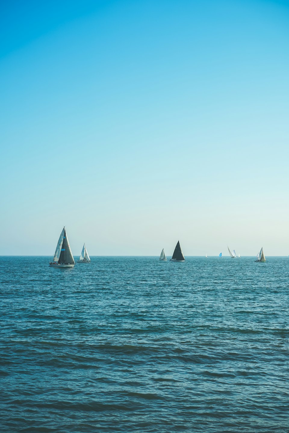 Veleggiate su un vasto oceano blu sotto un cielo limpido.