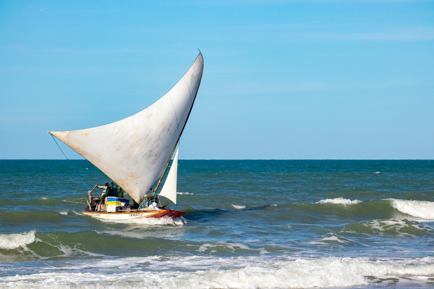 Vela triangolare su onde agitate dell'oceano.