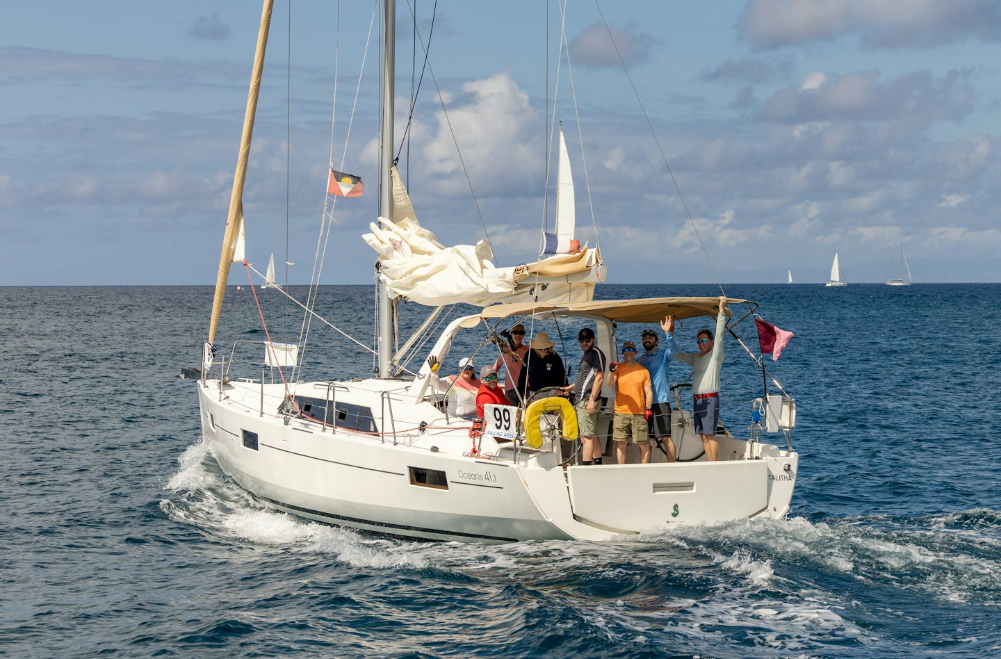 Persone salutano e sorridono mentre navigano in barca sull'oceano.